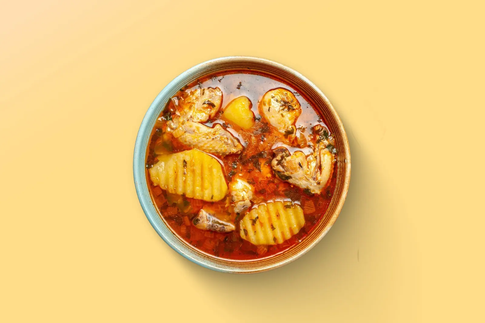 Massaman-Curry mit Kartoffeln in einer Schale, gelber Grund