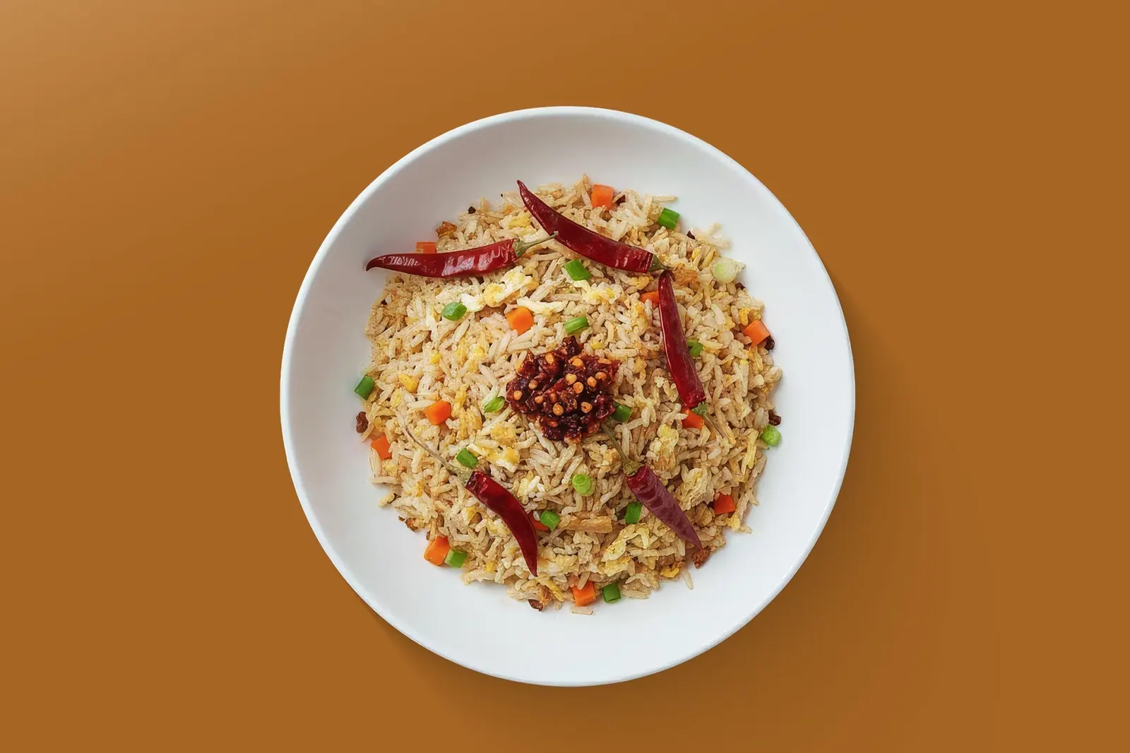 Fried rice with vegetables and chilli on a white plate